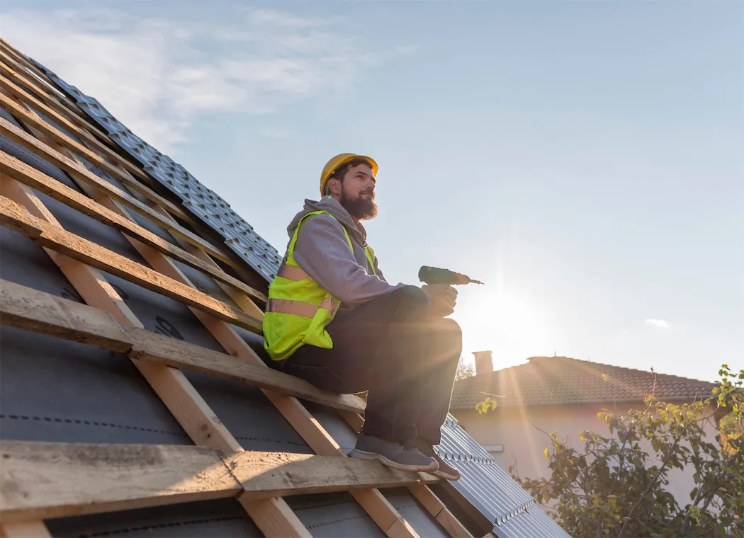 Professional contractor examining roof structure and solar panel layout plans, demonstrating proper preparation steps for combined installation projects