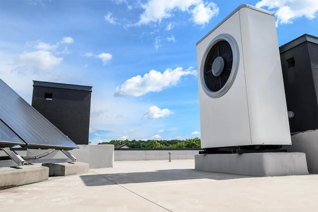 Modern rooftop installation showing integrated solar panels and HVAC system components, demonstrating efficient combination of renewable energy and climate control solutions