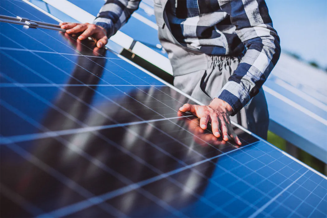 Close-up of solar panel installation and quality inspection showing detailed view of photovoltaic cells and mounting hardware, demonstrating professional solar system setup